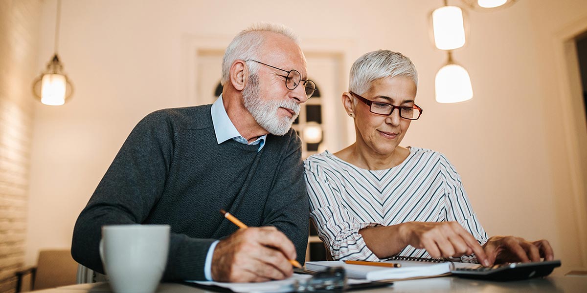 retired couple looking at bill, economic growth
