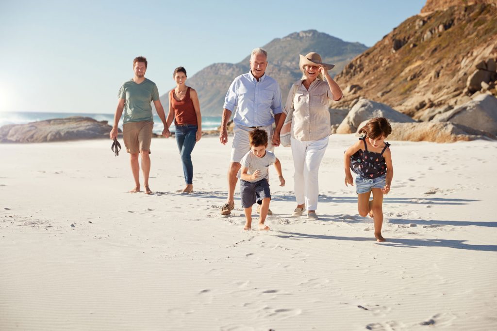 retirees with family walking on beach, traditional ira, roth iras