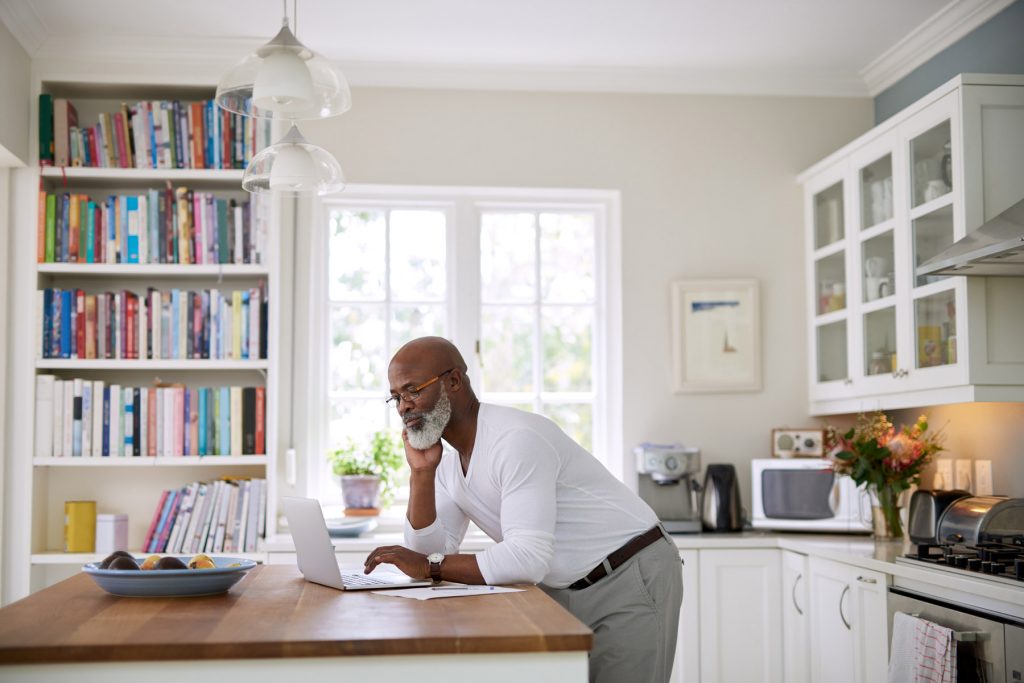 retired man researching on computer, income gap in retirement 