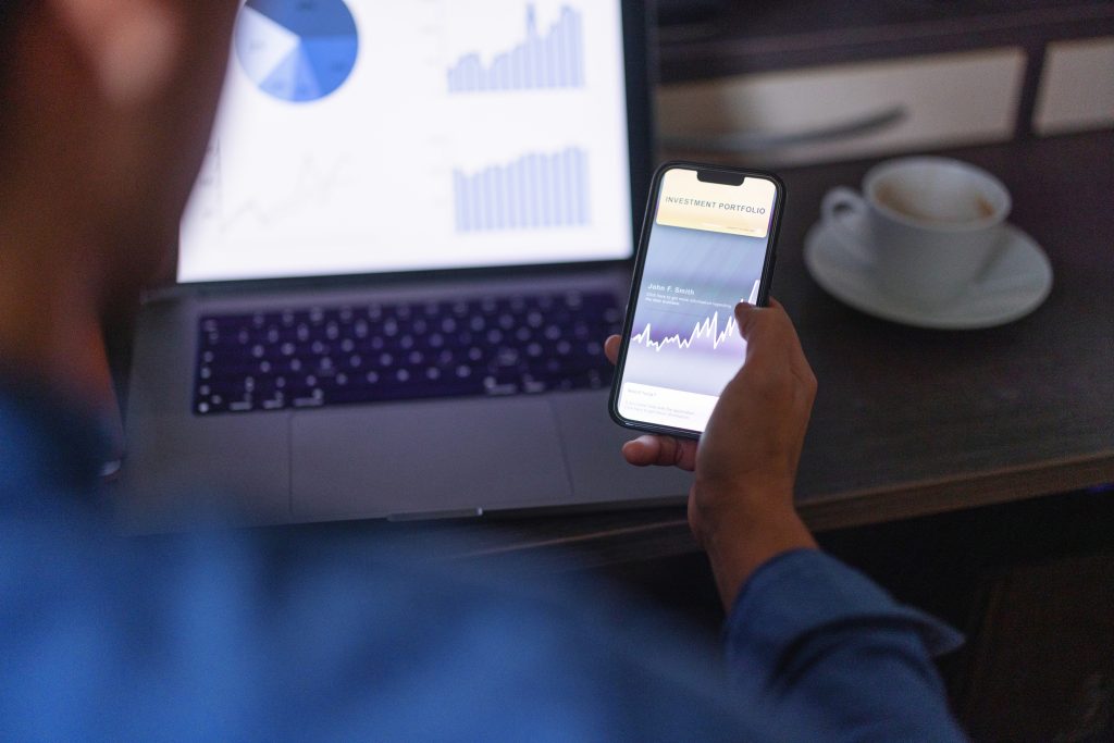 Close up shot of a man checking his investment portfolio on his phone, Is TIP ETF a Good Investment, TIP ETF